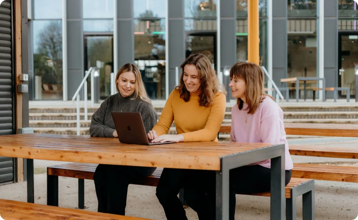 The famille team sitting at a desk, working together at a laptop